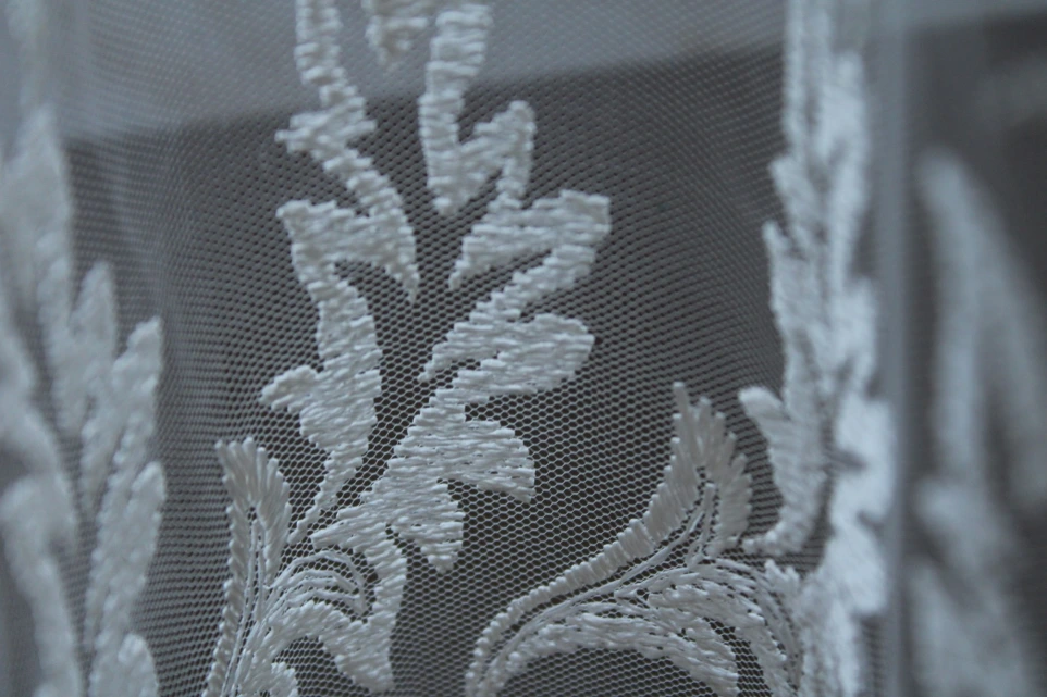 A close up of a window with white lace on it